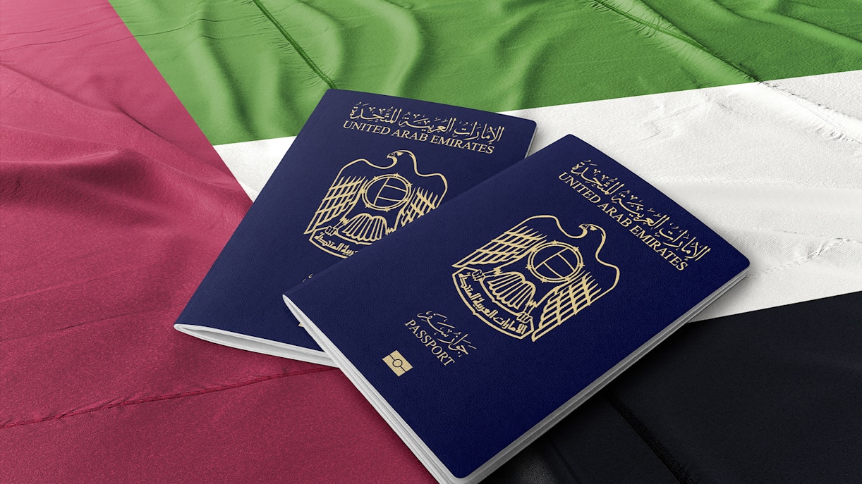 United Arab Emirates passports on UAE flag background.