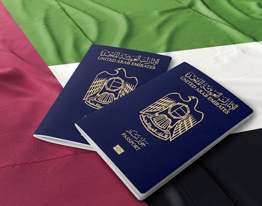 United Arab Emirates passports on UAE flag background.