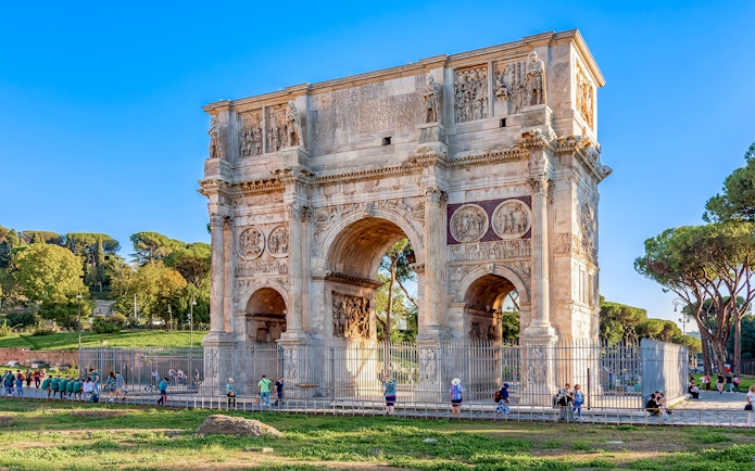 Arch of Constantine in Rome with tourists exploring the historic monument.