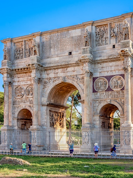 Arch of Constantine in Rome with tourists exploring the historic monument.
