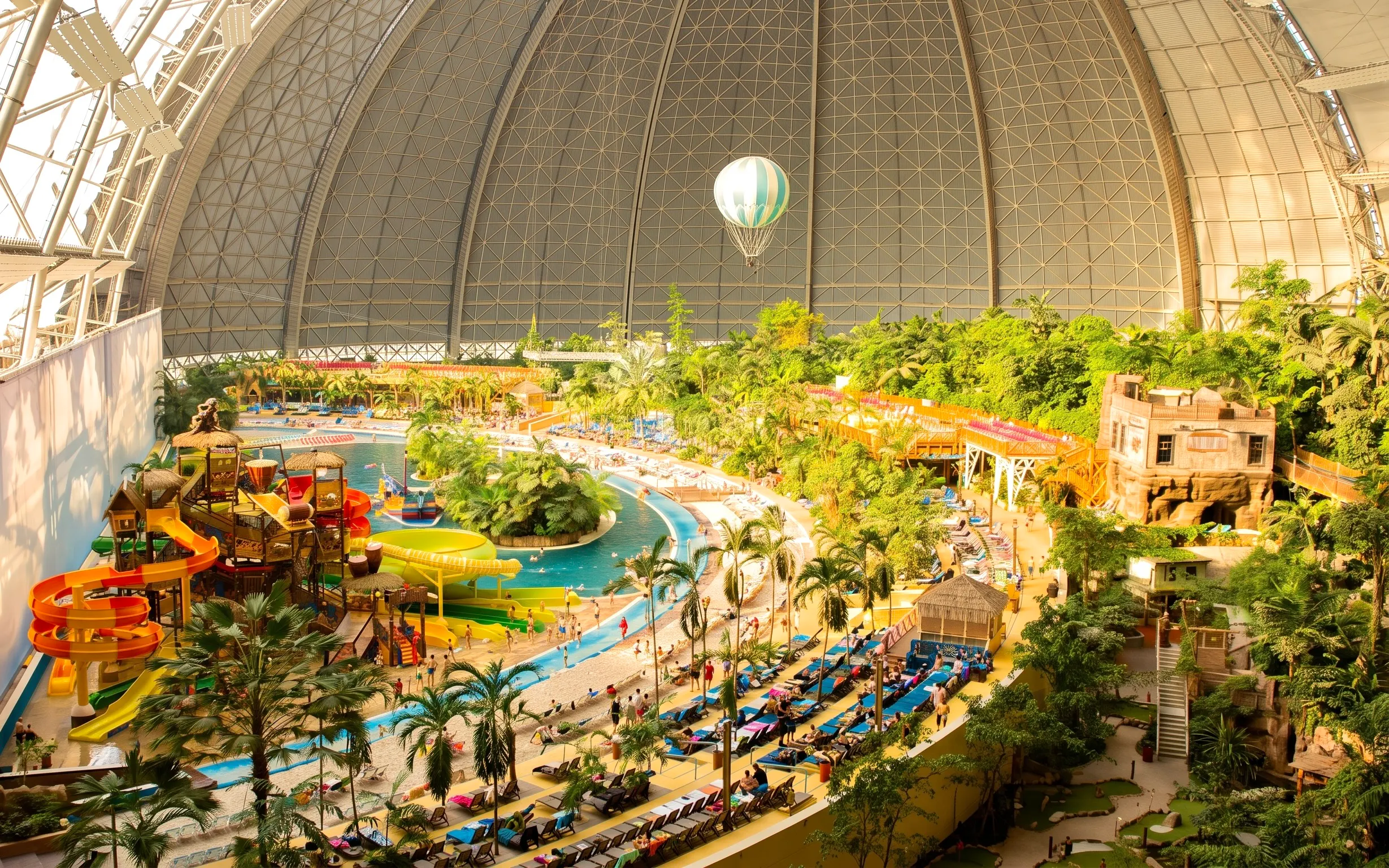 Indoor water park with slides and tropical plants at Tropical Islands Resort.