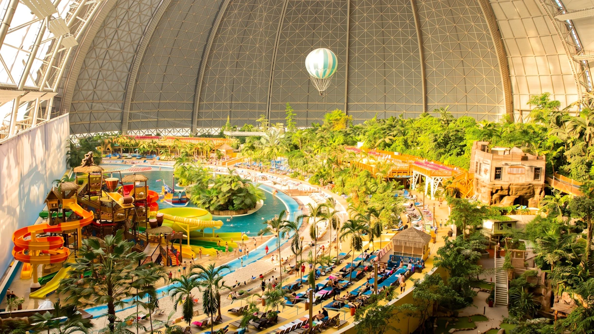 Indoor water park with slides and tropical plants at Tropical Islands Resort.