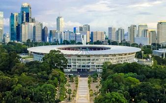 Gelora Bung Karno Stadium with Jakarta skyline in the background, part of the Jakarta City Walking Tour by MRT.