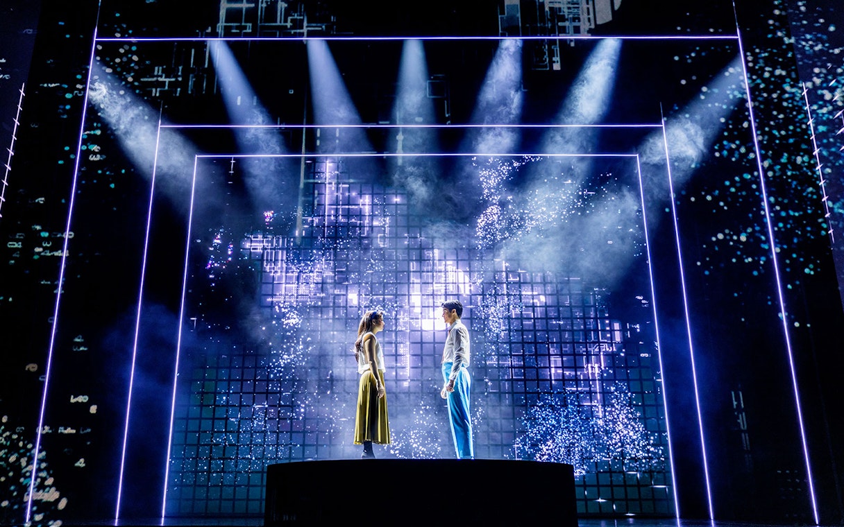 Actors on stage during Maybe Happy Ending Broadway show with digital backdrop.