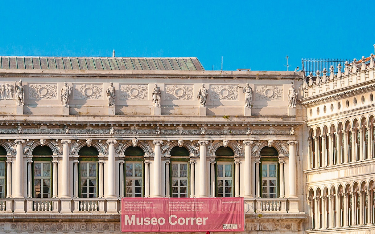 Correr Museum facade with classical statues and arched windows in Venice, Italy.