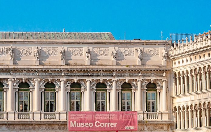 Correr Museum facade with classical statues and arched windows in Venice, Italy.