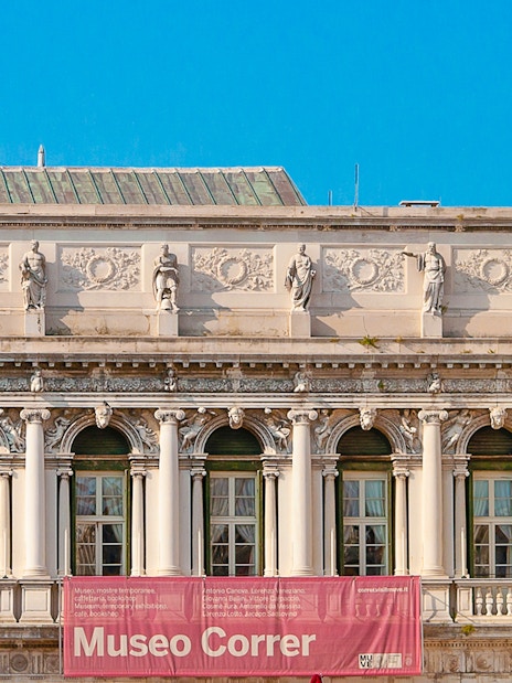 Correr Museum facade with classical statues and arched windows in Venice, Italy.