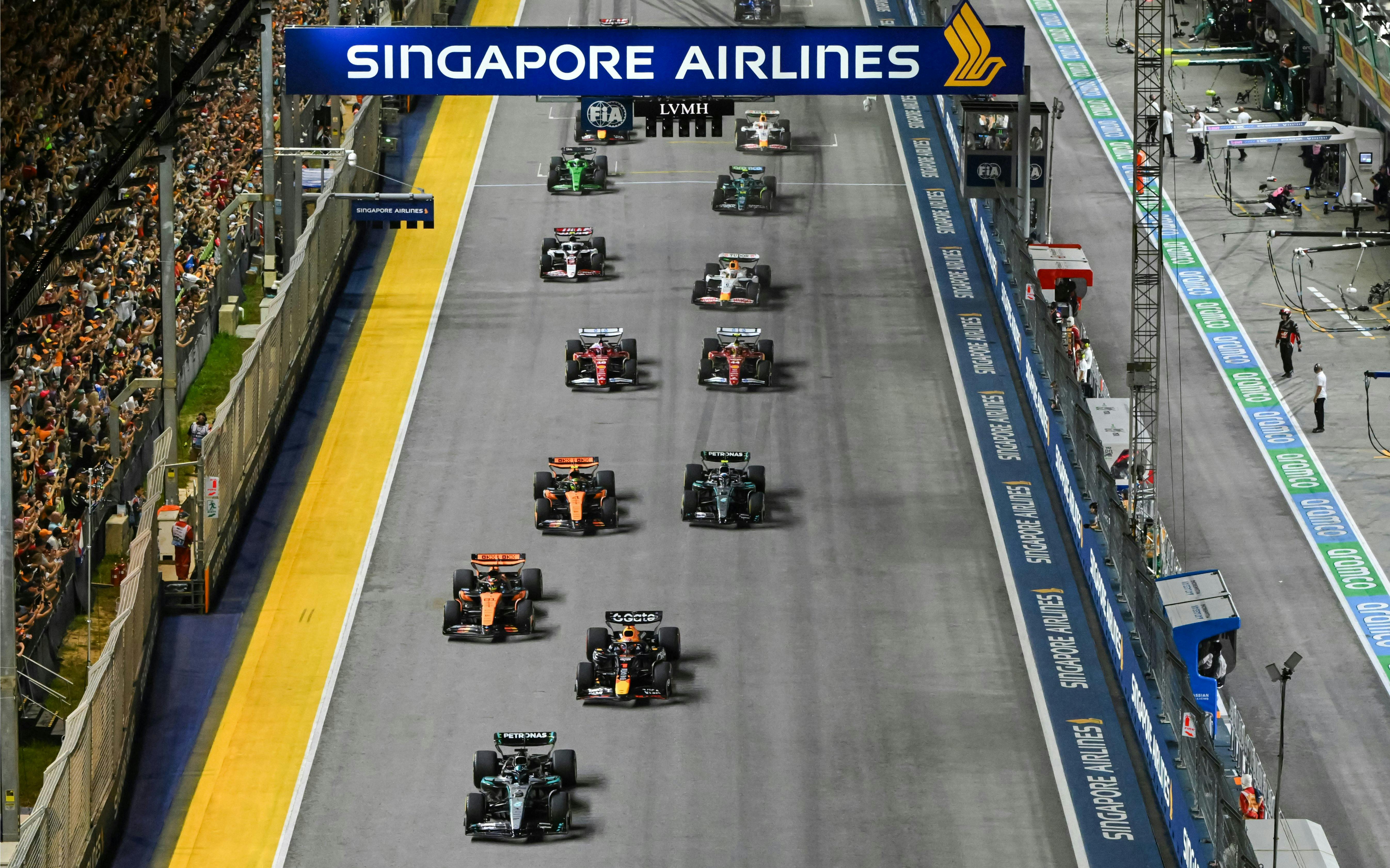 Cars racing on the track at Formula 1 Singapore Grand Prix night event.