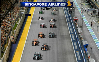 Cars racing on the track at Formula 1 Singapore Grand Prix night event.