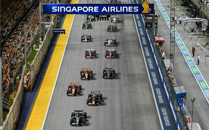 Cars racing on the track at Formula 1 Singapore Grand Prix night event.