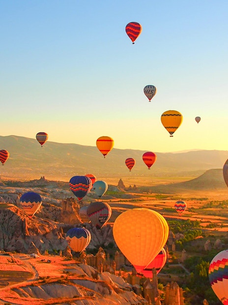 Hot air balloons over Luxor landscape at sunrise.