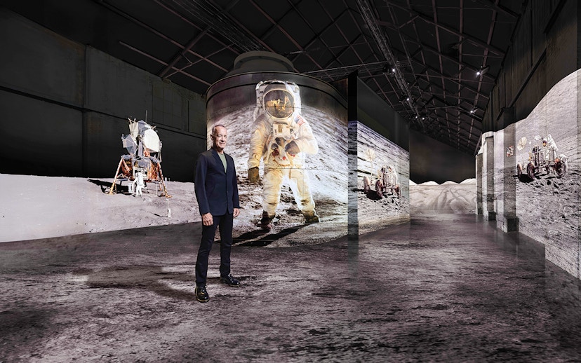Visitor at Moonwalkers Exhibition, Fabrique des Lumières, Amsterdam, with lunar landing visuals.