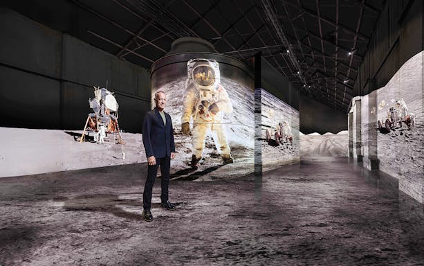 Visitor at Moonwalkers Exhibition, Fabrique des Lumières, Amsterdam, with lunar landing visuals.