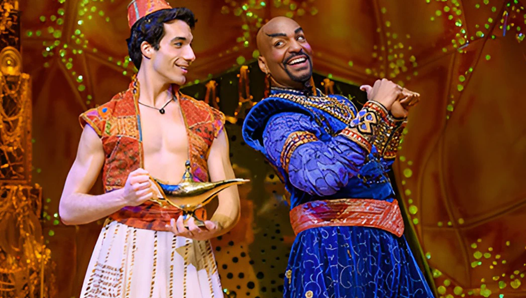 Characters from Aladdin The Musical on stage with a magic lamp.