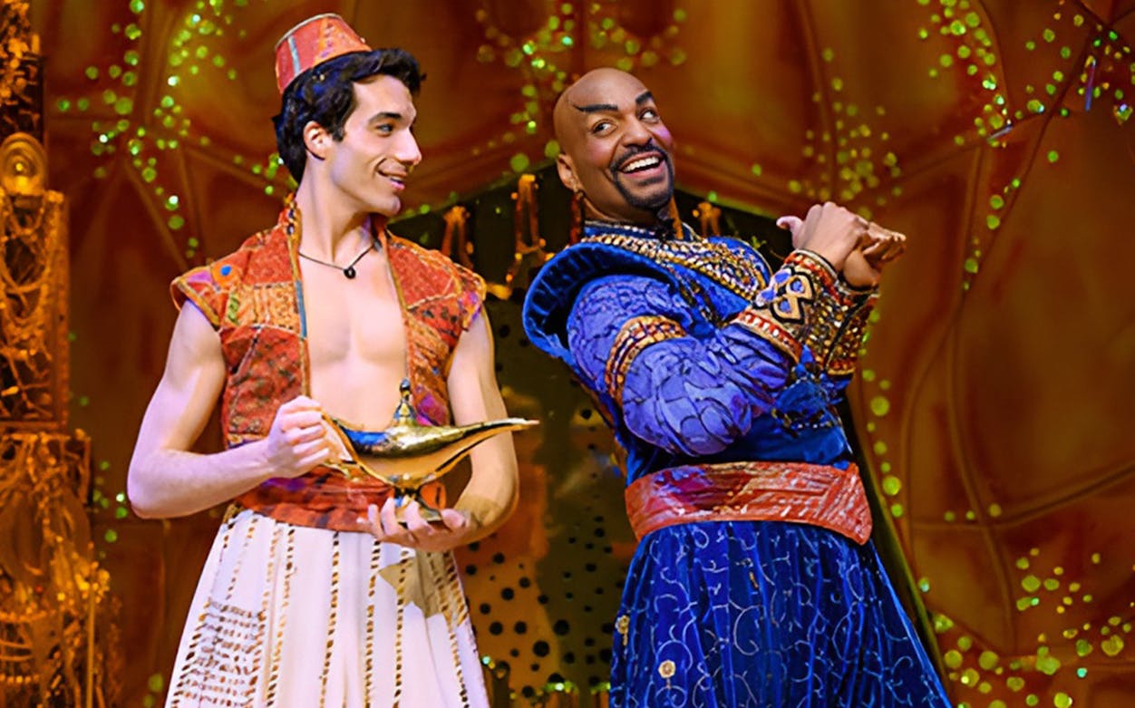 Characters from Aladdin The Musical on stage with a magic lamp.