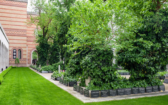 Great Synagogue garden with gravestones and lush greenery.