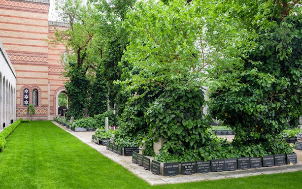 Great Synagogue garden with gravestones and lush greenery.
