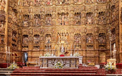 Seville Cathedral's Capilla Mayor altar with intricate gold carvings and religious figures.