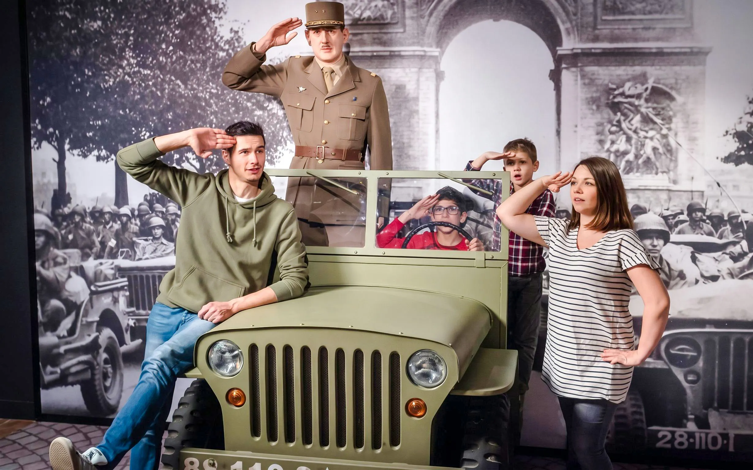 Visitors posing with a wax figure of a soldier at Grévin Wax Museum, Paris.