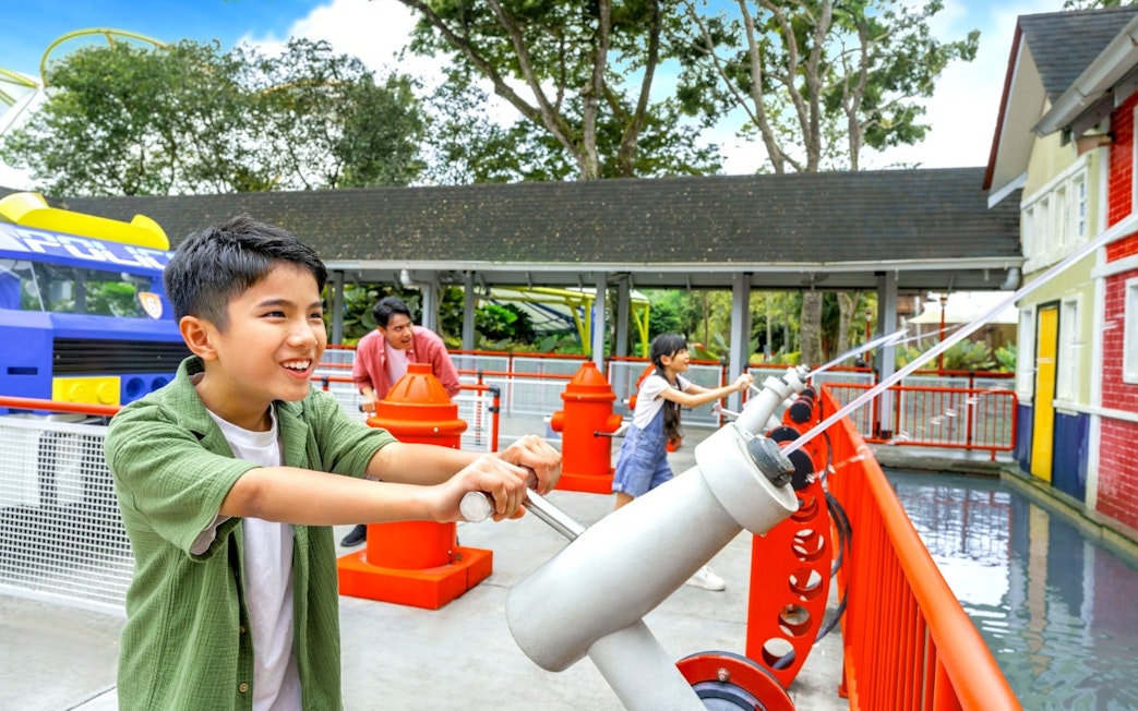 Children using water cannons at Rescue Academy, Legoland Malaysia.