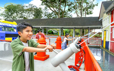 Children using water cannons at Rescue Academy, Legoland Malaysia.