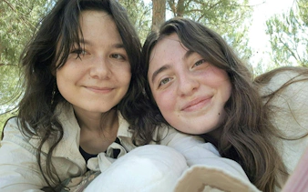 Two people smiling outdoors during a self-guided city exploration game in Madrid.