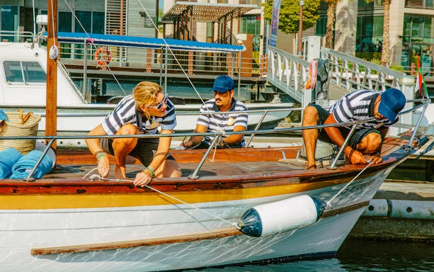 Boat crew preparing for Jumeirah swimming tour in Dubai marina.