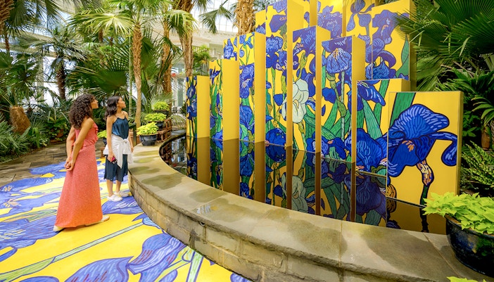 Visitors walking through the lush greenery of New York Botanical Garden.