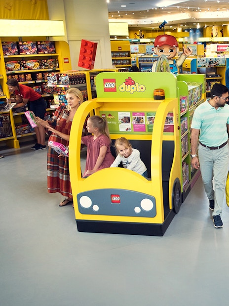 Families exploring LEGO displays at LEGOLAND® Dubai Hotel retail store.