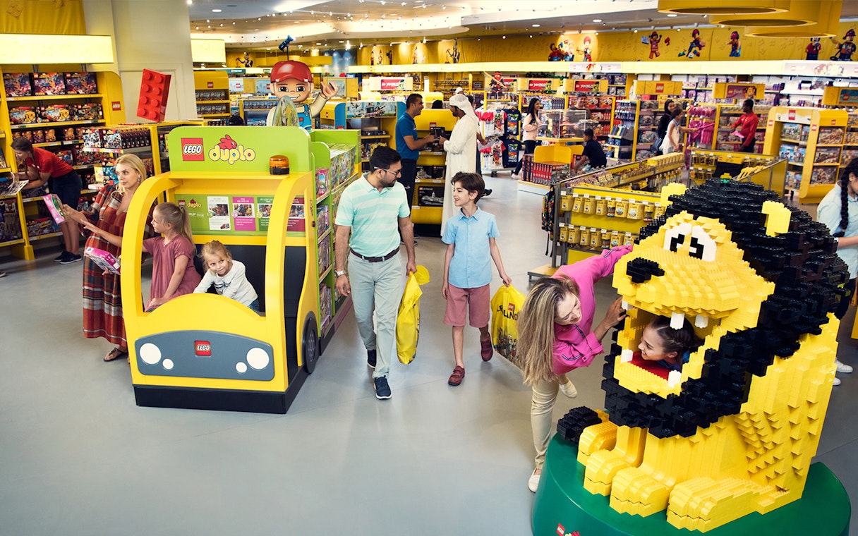 Families exploring LEGO displays at LEGOLAND® Dubai Hotel retail store.