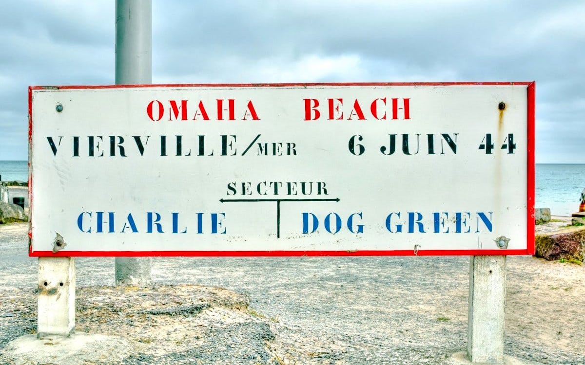 Sign marking Omaha Beach in Vierville-sur-Mer, France, with sector names Charlie and Dog Green.