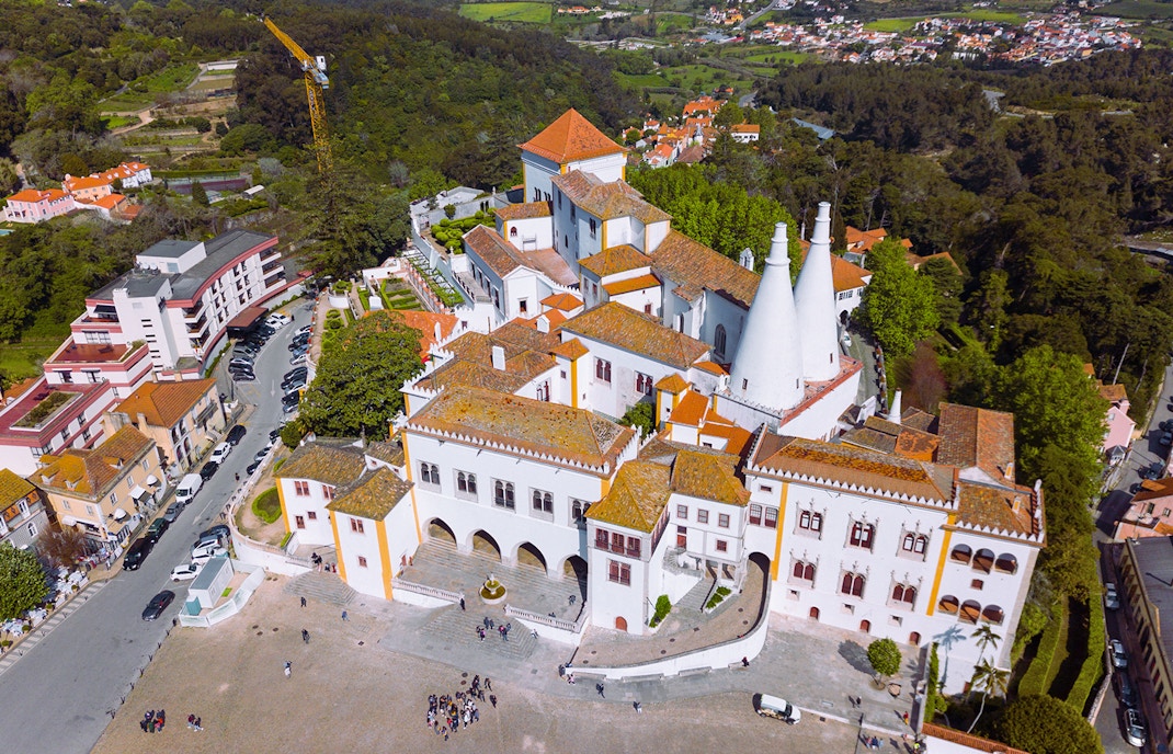 Aerial view of Sintra National Palace in Portugal with surrounding lush greenery.