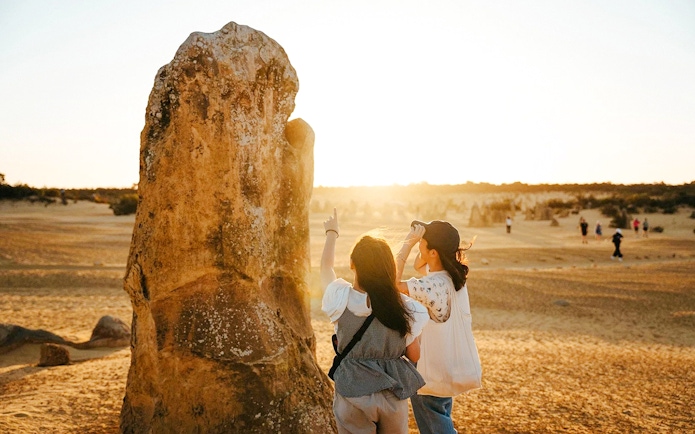 Visitors exploring Pinnacles Desert at sunset during stargazing and wildlife tour.