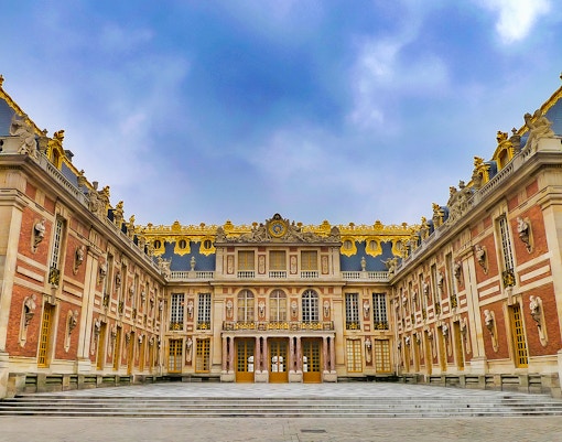 Versailles Palace exterior with ornate architecture and manicured gardens in Versailles, France.