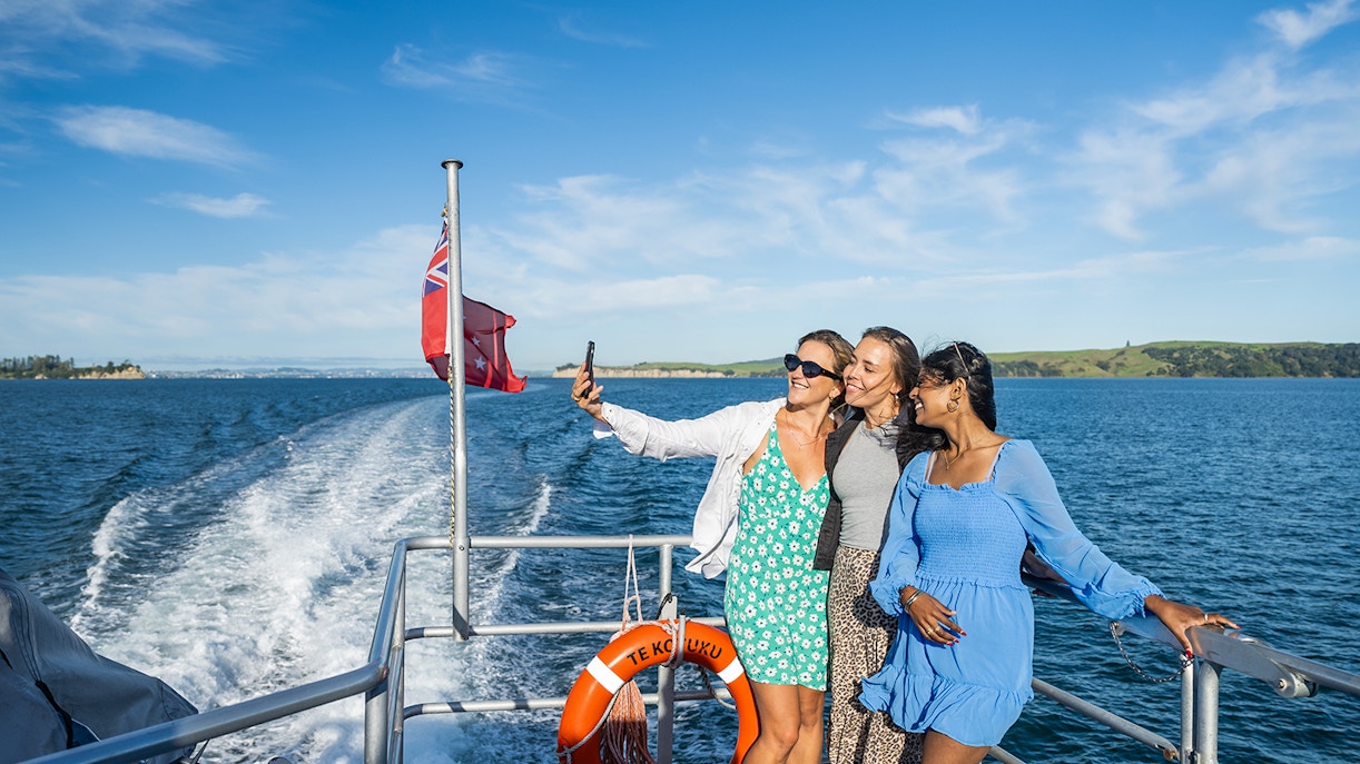 Women taking a selfie on a ferry to Waiheke Island, New Zealand.