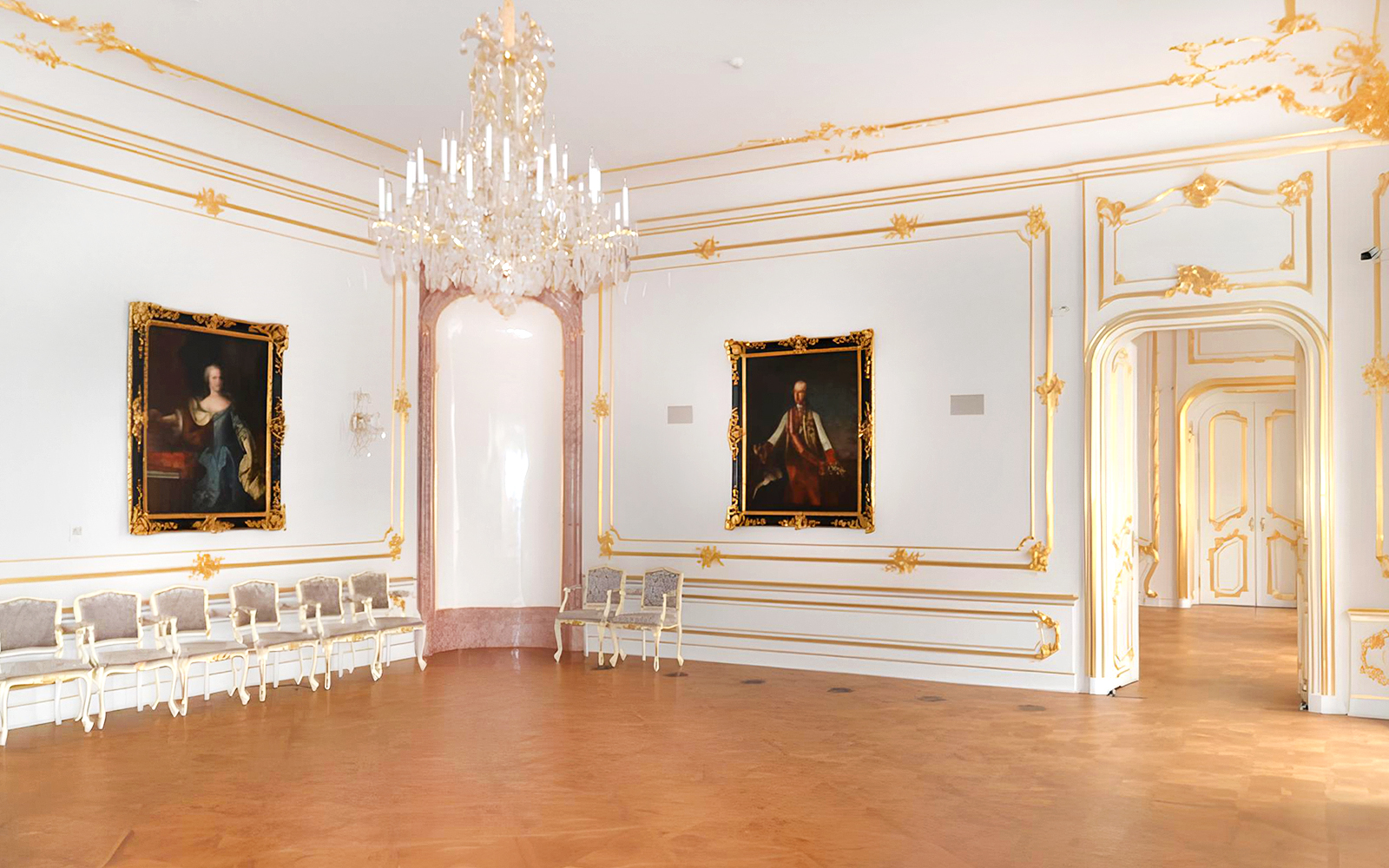 Elegant room with chandeliers and portraits inside Bratislava Castle.