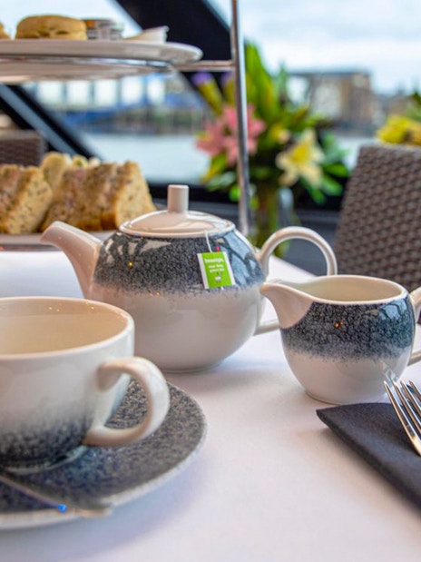Tea set and scones on table during Thames River Cruise.
