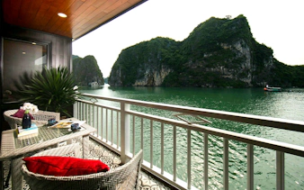 Junior double cabin balcony view of limestone karsts in Ha Long Bay on 5-star premium cruise.