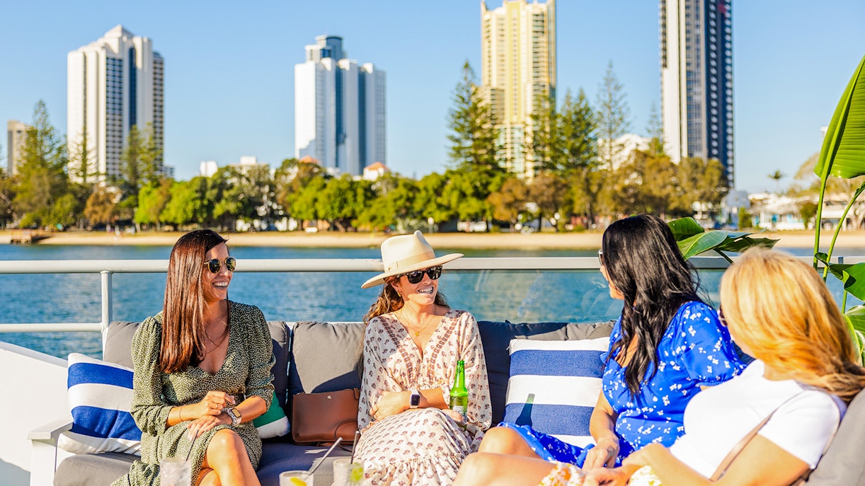 Ladies enjoying Gold Coast buffet lunch on top deck with city skyline.