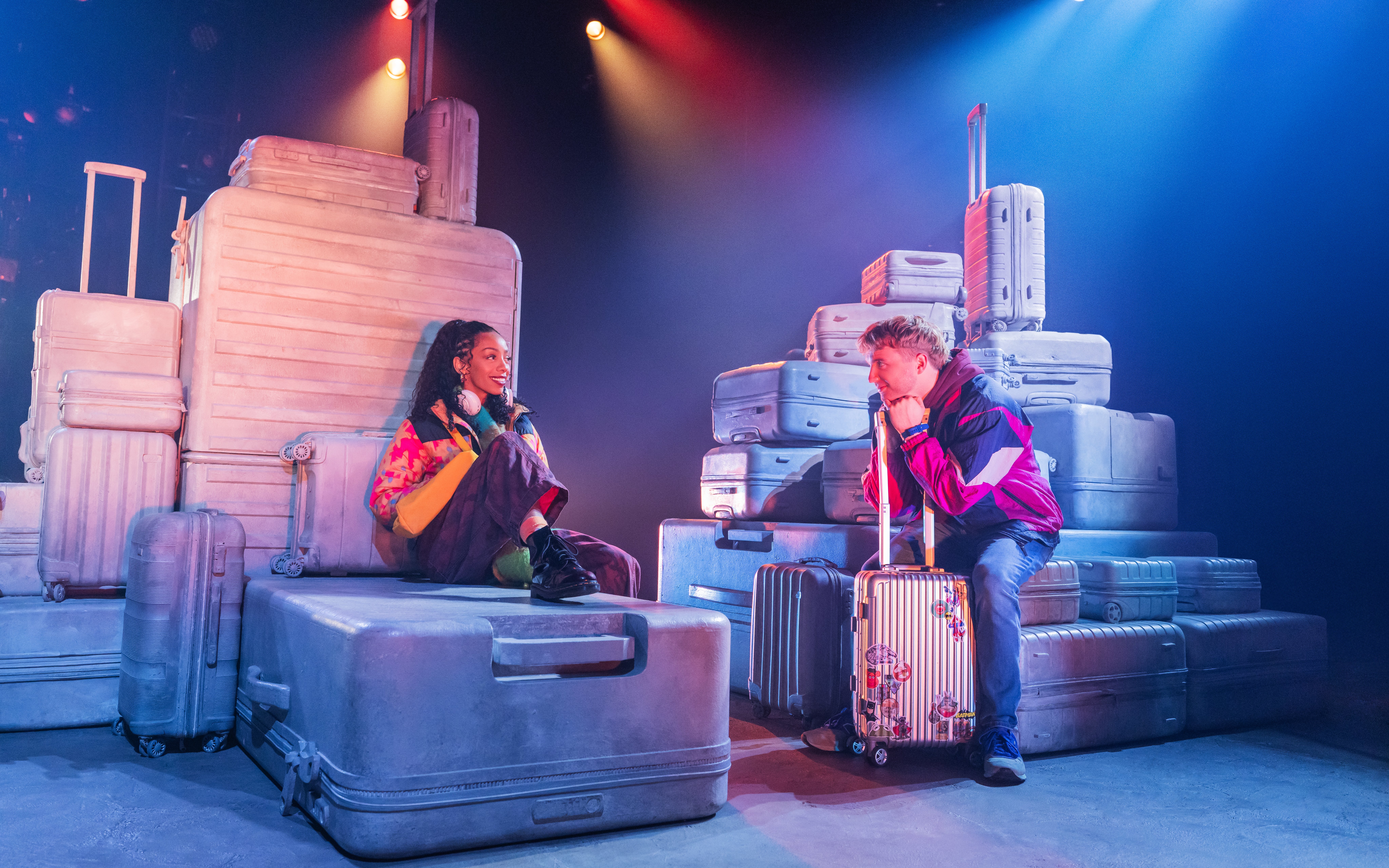 Actors surrounded by luggage in a scene from Two Strangers (Carry a Cake Across New York) Broadway show.