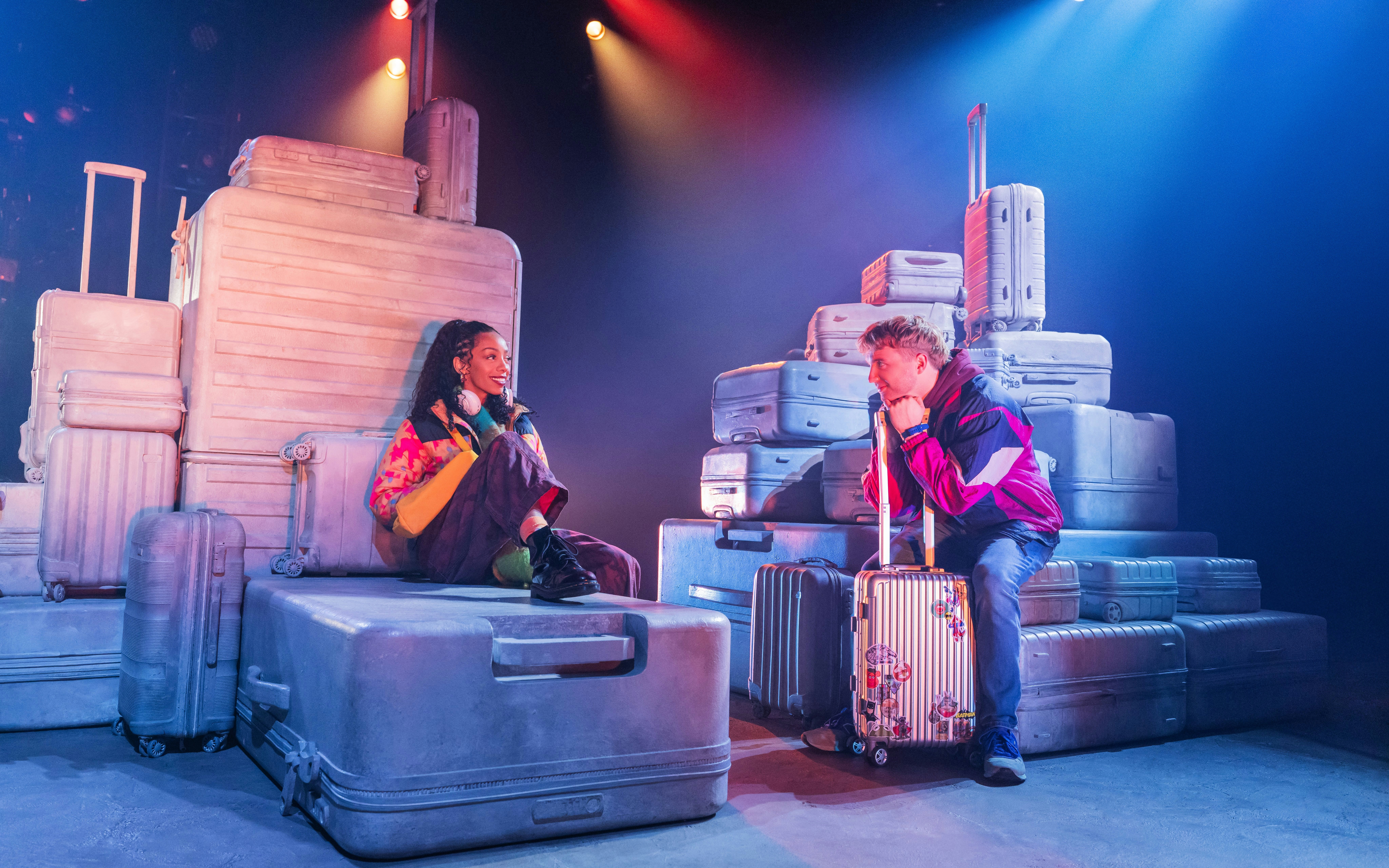 Actors surrounded by luggage in a scene from Two Strangers (Carry a Cake Across New York) Broadway show.