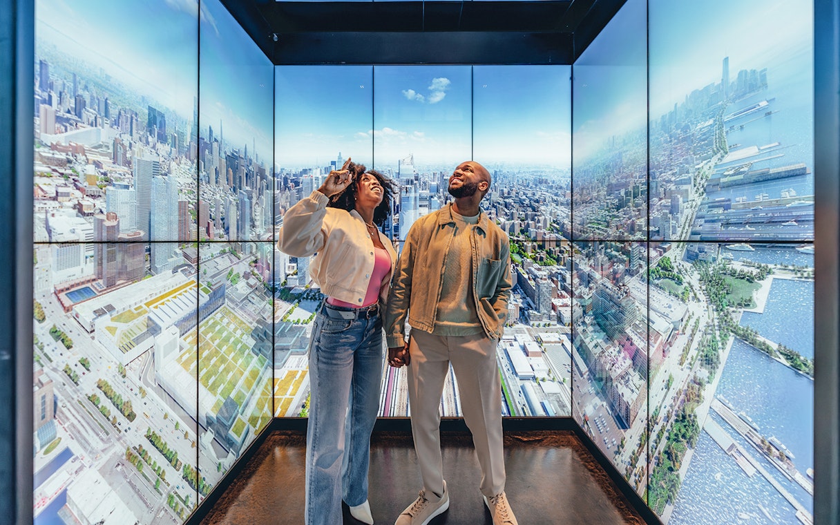 Couple enjoying city views at Empire State Building Observatory, New York.