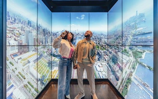 Couple enjoying city views at Empire State Building Observatory, New York.