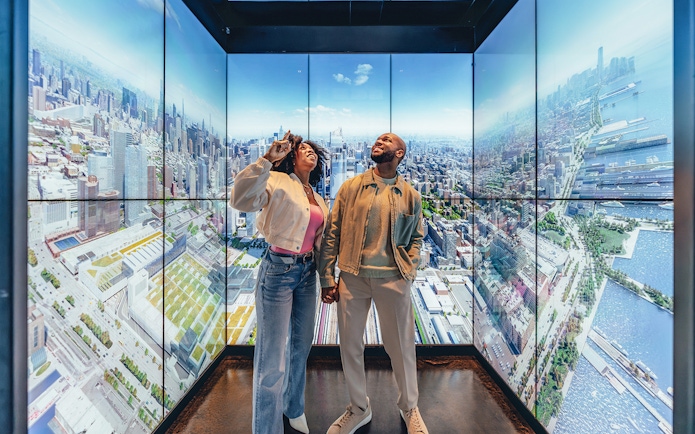 Couple enjoying city views at Empire State Building Observatory, New York.