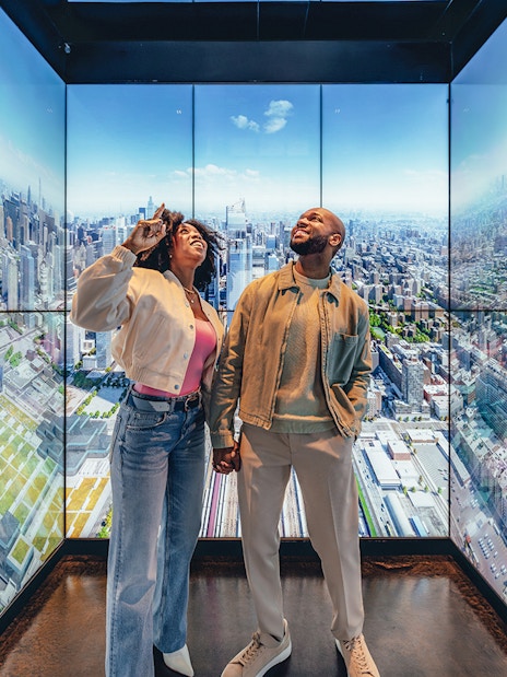 Couple enjoying city views at Empire State Building Observatory, New York.