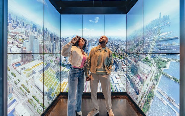 Couple enjoying city views at Empire State Building Observatory, New York.