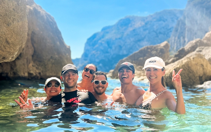 Group enjoying a kayak tour in Capri, surrounded by rocky cliffs and clear water.