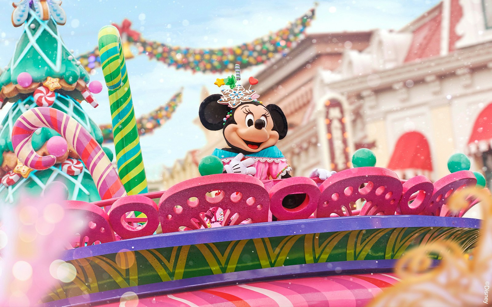 Mickey Mouse leading Christmas parade at Disneyland with festive decorations.