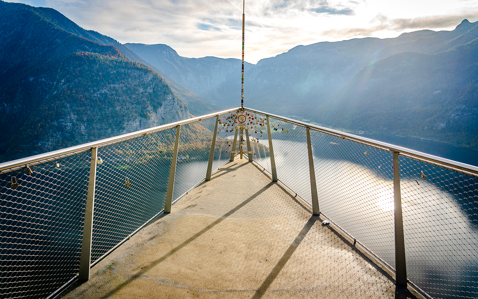 Skywalk lookout bridge overlooking Hallstatt, Austria with mountain and lake views.