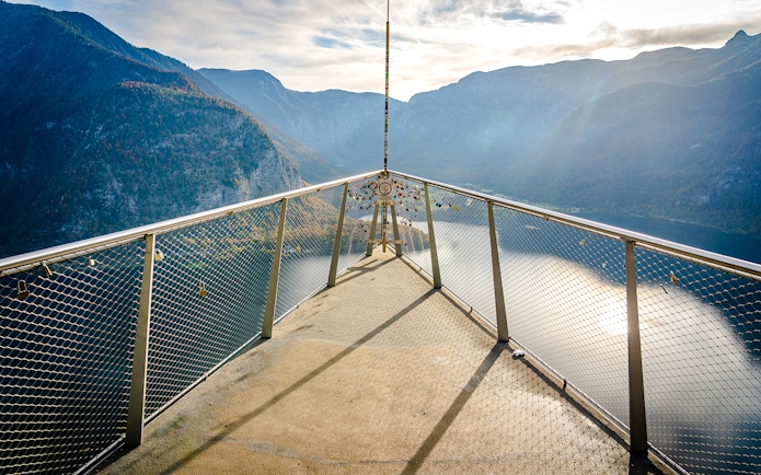 Skywalk lookout bridge overlooking Hallstatt, Austria with mountain and lake views.